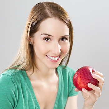 immagine di una ragazza sorridente con una mela in mano