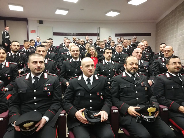 Foto di gruppo del ministro Grillo insieme ai Carabinieri seduti in aula