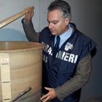 un carabiniere del NAS ispeziona un contenitore di vino