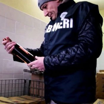 immagine di un carabiniere nas che controlla una bottiglia di vino