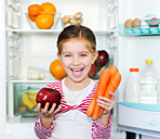 immagine di una bambina che prende frutta e verdura dal frigorifero
