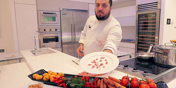 immagine di uno chef che mostra un piatto con il prosciutto tagliato correttamente