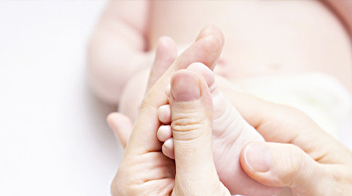 Immagine di mani che stringono i piedi di un neonato