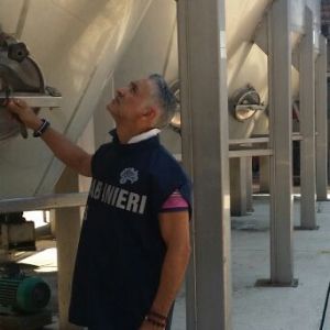 Un Carabiniere del NAS controlla un silos vinicolo