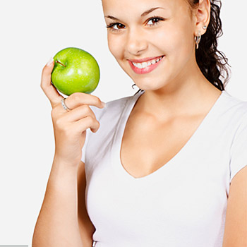 immagine di una ragazza sorridente che mostra una mela