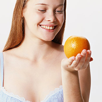 immagine di una ragazza con un'arancia in mano