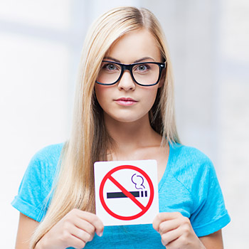 immagine di una donna che mostra un cartello di divieto di fumo