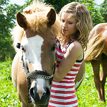 immagine di una bambina che accarezza un cavallo