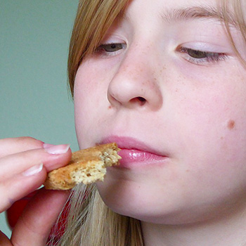 immagine di una bambina che guarda un biscotto