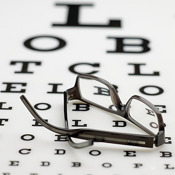 immagine di occhiali su un cartellone con le lettere e i segni per il test della vista