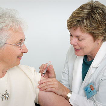 medico che sta vaccinando una donna anziana