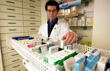Immagine di un farmacista che prende dei farmaci da un cassetto