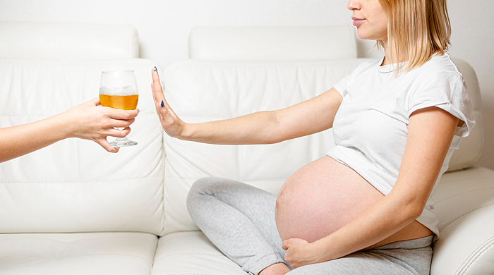 donna in gravidanza che rifiuta un bicchiere di alcol