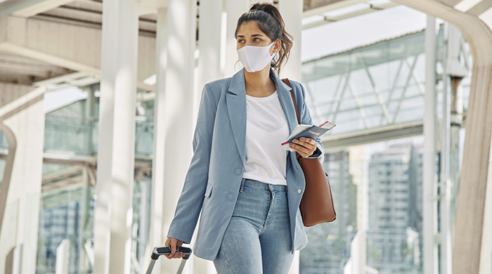 Viaggiatrice con mascherina in aeroporto