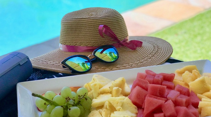 immagine di cappello, occhiali da sole e frutta