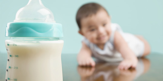 immagine di una bottiglia di latte con un neonato sullo sfondo