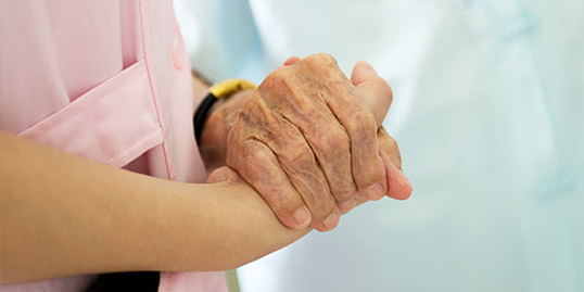 immagine raffigurante la mano di un medico che tiene la mano di un paziente