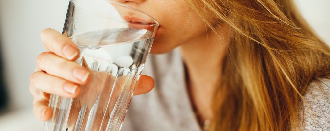 donna che beve un bicchiere di acqua