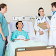 paziente in letto di ospedale circondato da personale sanitario